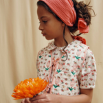 La face avant de la blouse festonnée floresco de la marque Emile & Ida portée par une enfant